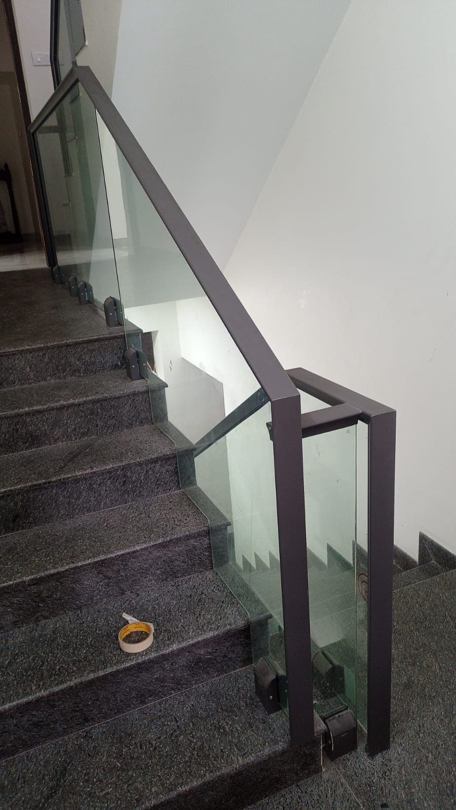 Staircase glass railing with a dark metal frame, site view