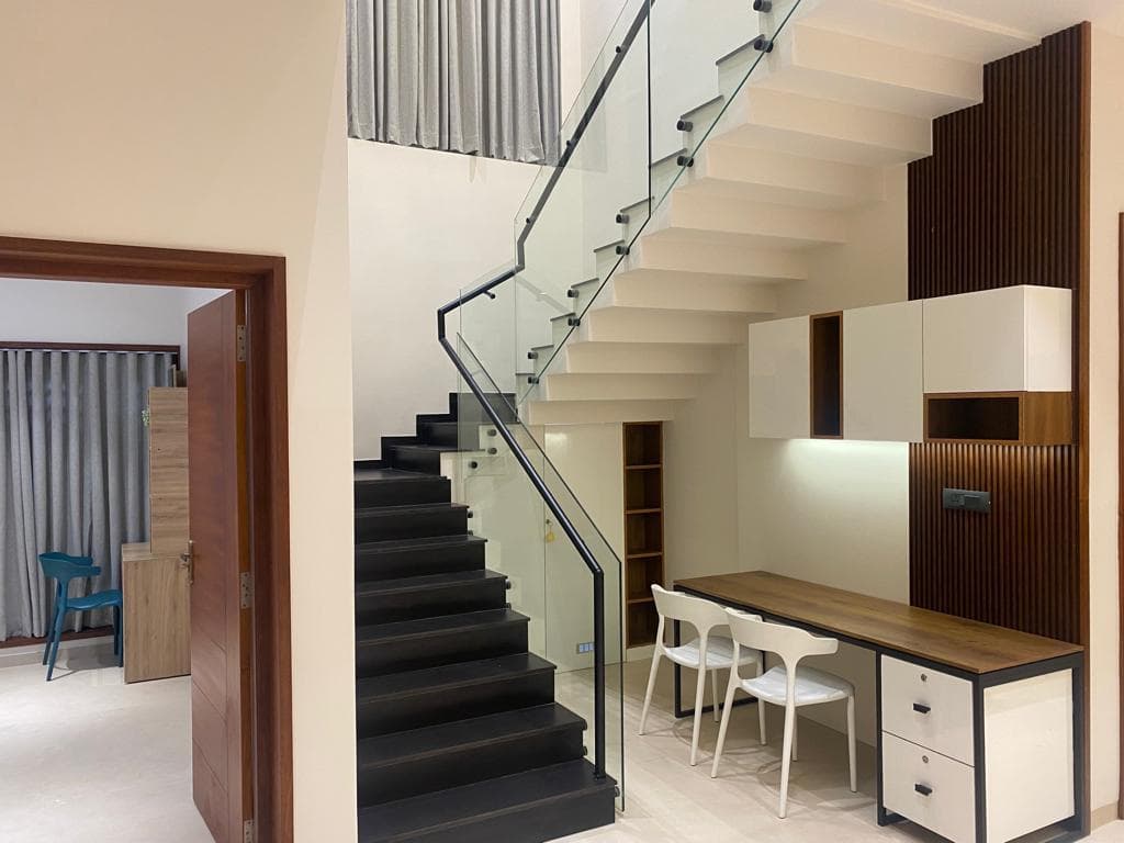 Staircase with a glass railing and timber handrail in a home interior