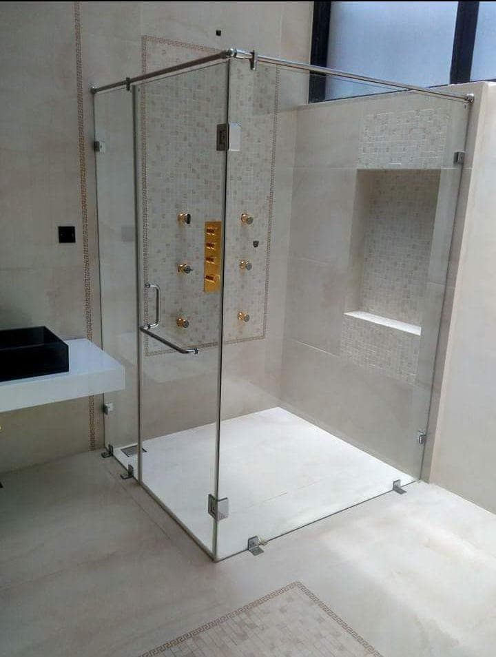 Glass shower enclosure with metal fittings